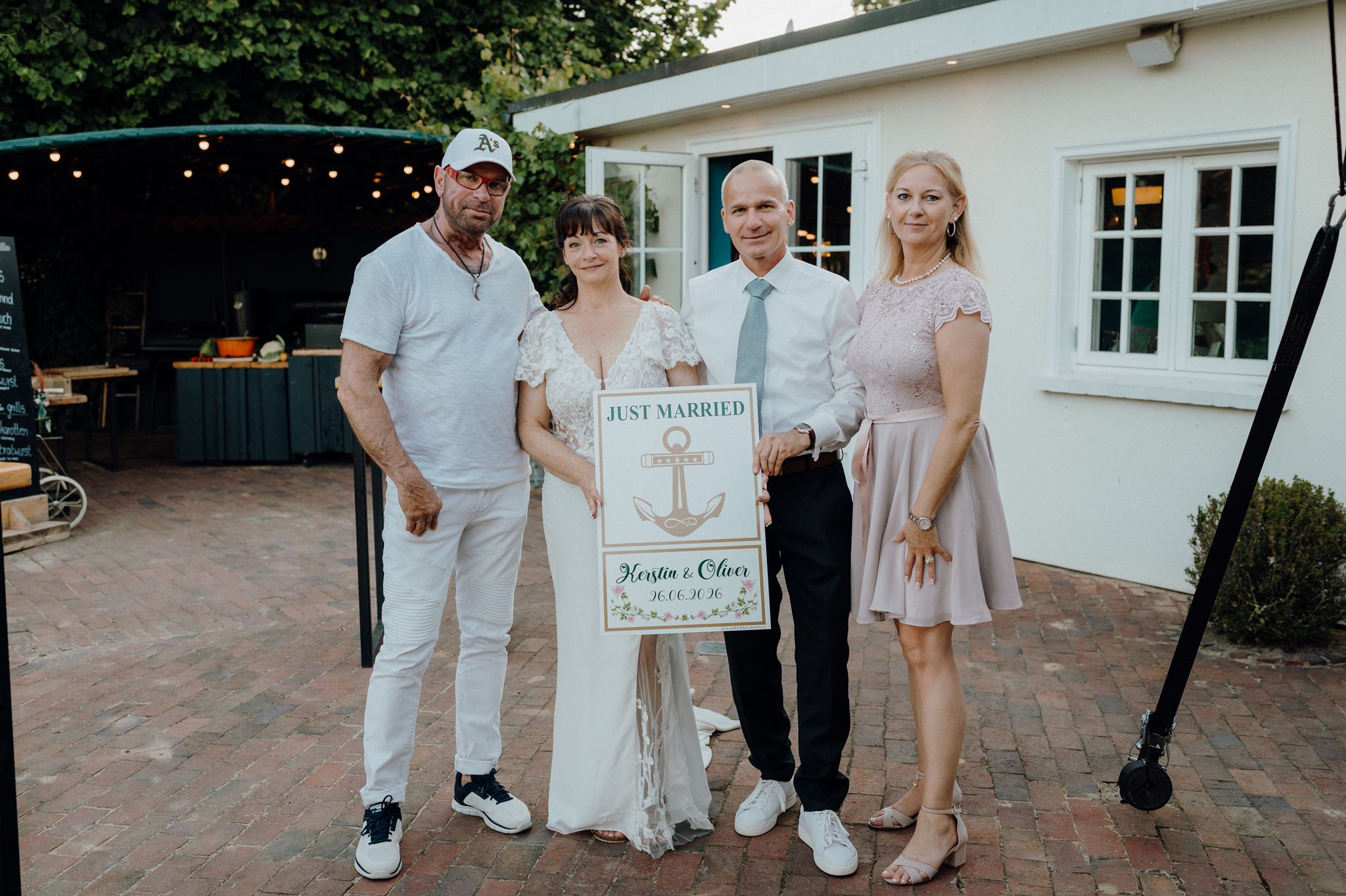 Brautpaar mit der Just-Married-Tafel und den Schenkenden
